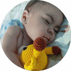 Gael sleeps peacefully with his stuffed giraffe.
