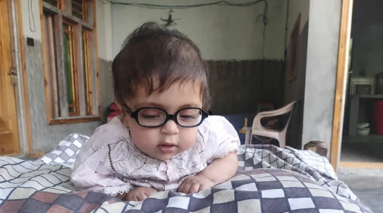 Ayesha wearing glasses while lying on patterned pillows
